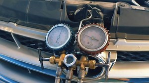 Download The mechanic is servicing the car's AC manually. for free