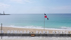 Santo Domingo Sans Souci written with big white letters and Dominican Republic flag on jetty. Aerial
