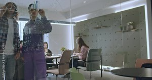 Colleagues brainstorming solutions and solving tasks in a modern office, writing on a glass board. Collaborative teamwork and problem solving.