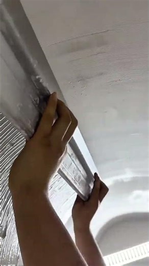Applying decorative plaster texture to curved ceiling surfaces using manual tools