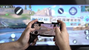 HELSINKI, FINLAND - JAN 21, 2021: A man playing Call of Duty on a smartphone - popular multiplayer cross-platform game. Leisure time during quarantine and self-isolation