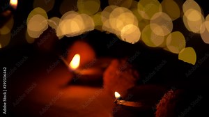 Person Illuminated Diwali Diya Lamps At Temple. Diya or clay lamps illuminated or lighted by a woman or girl in Indian festival called Diwali at a temple. Concept for Indian culture, festivals.