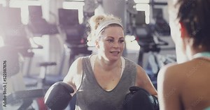 Boxer, athlete and fighter boxing, training and exercising in a gym, hitting a punching bag and working out for cardio and endurance. Chubby, plus size and overweight woman practicing for a fight