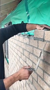 Pointing mortar between brick joints to finish and seal a masonry wall