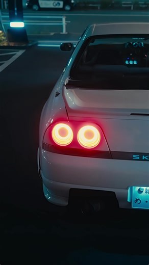 White GTR Illuminated by City Lights in Japan