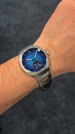 Koscom Hodinky on Instagram: "Základem číselníku @moserwatches Streamliner Small Seconds Blue Enamel 6500-1200 není mosaz, ale zlato. Na něj je vytepán zrnitý vzor, který vytváří texturu připomínající tepaný kov. Následně přichází na řadu alchymie smaltování. Řemeslníci nanášejí tři různé barevné pigmenty, které se po výpalu v peci (proces se opakuje dvanáctkrát!) slijí do fascinujícího gradientu zvaného Aqua Blue. Výsledek? Ciferník nemá jen barvu, má hloubku a texturu. Smalt Grand Feu je extré