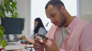 Man Worker Looking at Motherboard It Company Guy Master Checks the Electronic Board and Performs