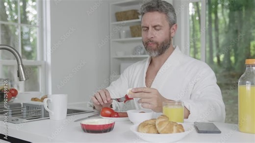 Man eat food. Morning breakfast. Healthy breakfast in morning. Mature man eating breakfast in kitchen, healthy lifestyle. Hispanic man having home breakfast. Home morning yummy food