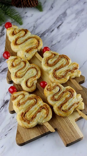 Puff Pastry Christmas Trees 🎄 I’ve seen this cute idea all over and had to give it a try! It really is as simple as it looks! I filled it with biscoff, but you could use your favorite spread. INGREDIENTS: -puff pastry -biscoff spread or filling of choice -egg wash (one egg beaten) Lay out a sheet of puff pastry and spread on a layer of biscoff. Place a second sheet of pastry on top to sandwich the two together. With a knife or pizza wheel, slice the pastry into 1 inch strips. Fold the strips in