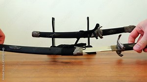 denuding a samurai sword blade from a scabbard