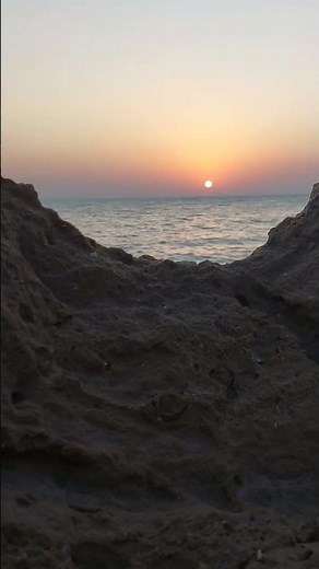 Beautiful view of the sun and sea behind the rocks.