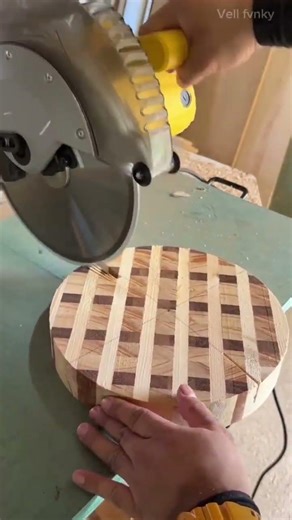 Cutting round checkered wood board into several pieces using electric circular saw in the workshop