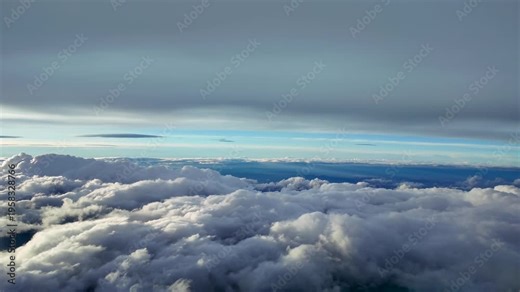 Immersive cockpit view flying through a serene cloudscape as seen from a jet cockpit, with the clouds illuminated by the light of sunrise early in the morning.
