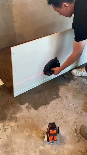 Worker using suction cup tool to install large floor tile
