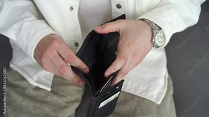 man with an empty wallet. A man holds an empty wallet in his hands.