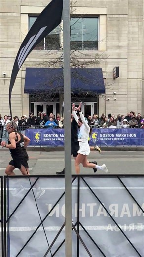 Runners dressed as bride and groom compete in the 2026 Boston Marathon