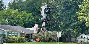 Tree-cutting crane flips over, crashes into home