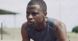 Black man, start and getting ready for running, race or outdoor exercise in fitness or competition on stadium track. Active African male person or athlete in training for sprint or sports marathon
