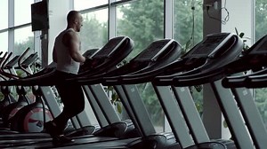 Man Jogging on Treadmill in Modern Gym