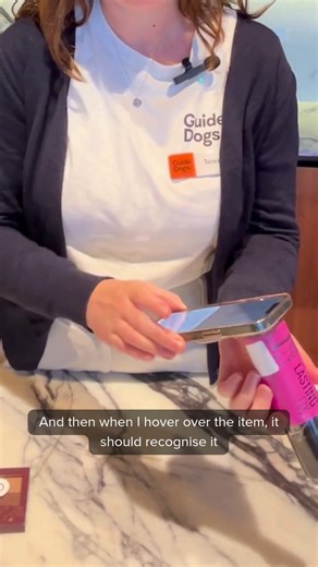 Here’s is another example of accessible labelling, WayAround tags. Demonstrated by Occupational Therapist, Teresa. For more information about our Assistive Technology Services, visit our website and seach 'Assistive Technology'. [Video description: Occupational Therapist, Teresa, stands behind a bench explaining how WayAround tags work. She holds her Smartphone up to a sticker on the bottom of a spray bottle and reads out the information recorded in the app. The Guide Dogs logo appears.] | Guide