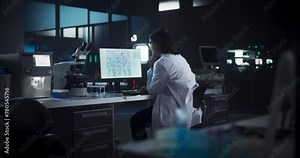 Caucasian Female Scientist Working on a Computer in the Evening. Specialist Using a Gene Sequencing Software. Advanced Biotechnology Lab in a Medical Research and Development Center Stock Video