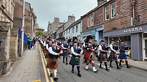 Drum Major Alan Brand leading the massed Pipe Bands through the streets of Crieff as they marched to the 2024 Crieff Highland Gathering in Perthshire, Scotland. This is part of the Chieftain's Parade through the town on Sunday 18th August 2024. Drum Major Brand was with Alyth & District Pipe Band, and the other bands taking part here were Comrie Pipe Band, The Vale of Atholl Pipe Band, Blairgowrie, Rattray & District Pipe Band, Doune Pipe Band and Kinross & District Pipeband, all playing the Gre