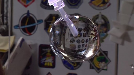 Astronauts play with floating ball of water in space - video