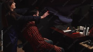 woman hairdresser throws a cape on the client before the haircut, slow motion