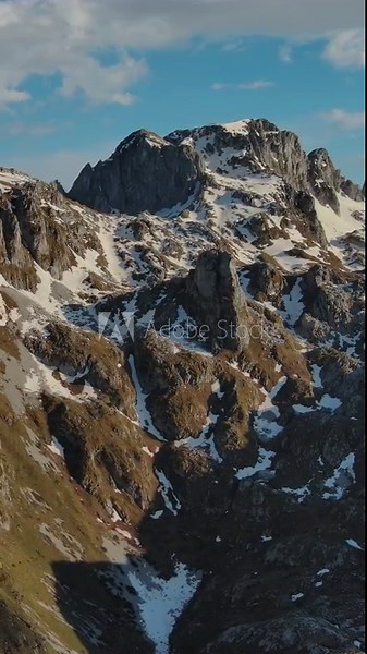 Aerial view of amazing rocky mountains in snow before sunset, Prokletie, Montenegro. Vertical video 4k