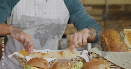 Male baker entering carrying bread basket onto countertop and arranging rolls for bakery display