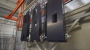 Manufacture. Process of anodizing aluminum plates in production, Immersion of aluminum plates in liquid. Automatic production line.