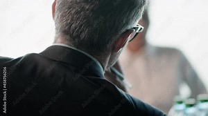 A back view of a head of an adult businessman sitting in the office during conference