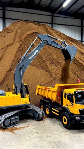 A remote-controlled excavator is loading sand