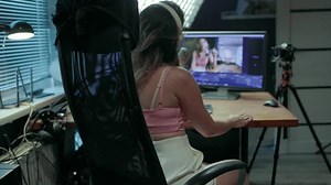 A beautiful brunette woman blogs and broadcasts live from her home video studio