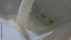 Plastic pelletizer recycling machine: recycled plastic granules, pellets are falling into metal container - final stage: collecting, close up view. Reuse, waste reduction and industrial concept