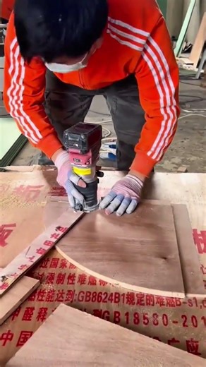 Shaping and trimming a curved wooden board using a power router tool for a custom furniture project