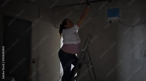 A confident woman on a ladder, passionately working on a home renovation project, showcasing her creativity