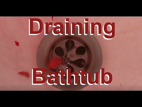 Close up of vortex in bathtub which drains with red water