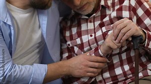 Man visiting his disabled father in nursing home, supporting and comforting him Stock Video