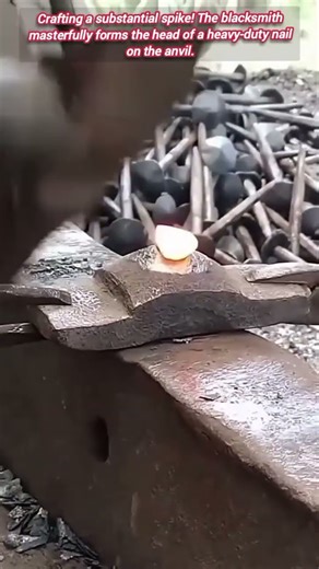 Blacksmith rapidly hammers the head of a massive nail.