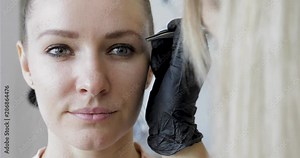 Eyebrows tweezing procedure footage. Brows correction with cosmetic tweezer.