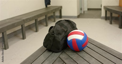 On recording start, black duffel bag and volleyball sitting on locker room bench awaiting practice