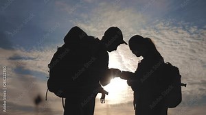 teamwork tourism navigation concept. happy family hikers silhouette in nature looking in a smartphone navigation path. man and lifestyle woman with backpacks silhouette in nature searching the road