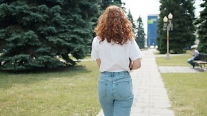 clip-1037842646-back-view-pretty-girl-walking-outdoors-green