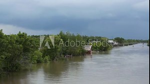 Time lapse recording of clouds above the river in the Mekong Delta in Vietnam. Some smaller boats moving, flat waves on the water.