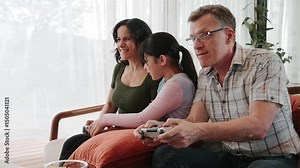 Granddaughter guide grandmother how to play console game with grandfather. Senior use technology activity communicate new generation kid cross generation gap strengthen family bond. Divergence. Stock Video