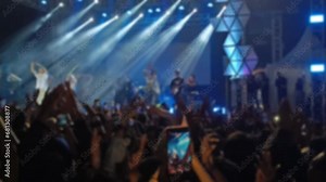 Defocused Abstract Background of Cheering concert crowd with colorful stage light, silhouette of Large group of people audience at live music festival