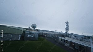 Daring and risky aerial flying through a satellite station setting in a bleak cold surrounding