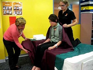 Sitting a person up in bed with slide sheets