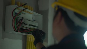 Download Electrician using electric screwdriver tester to check electric current in control box in home electrical installation and safety concept for free